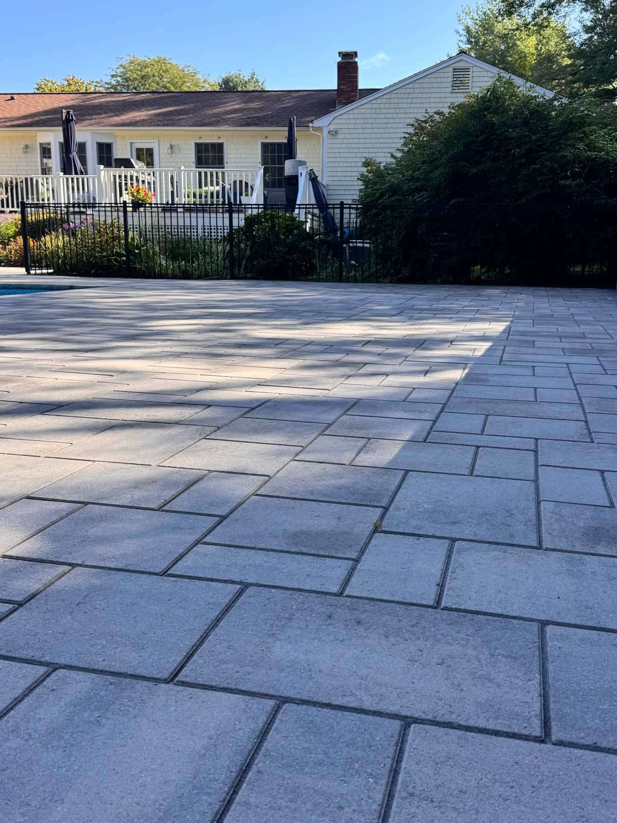 Freshly sealed paver pool patio in Rhode Island, shown from a second angle